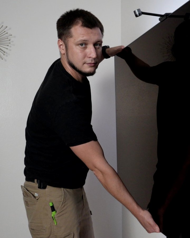 Russell, owner of TV Mount Boss, hanging a large TV on a wall mount